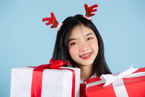 Happy Asian in Santa Claus costume holding Christmas  gift box o - Photo, Image
