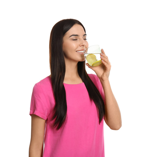 Beautiful young woman drinking tasty lemon water on white backgr - Fotoğraf, Görsel