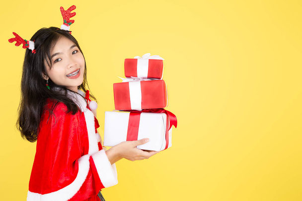 Happy Asian in Santa Claus costume holding Christmas  gift box o - 写真・画像