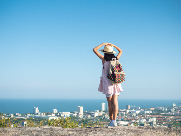 Back of girl raising hands on the top of city view, lifestyle co - Foto, Bild