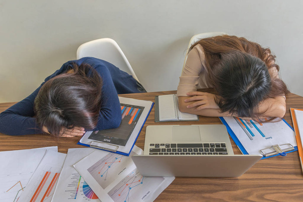 Two office girls sleeping on working desk - Foto, imagen