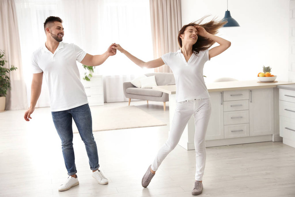 Lovely young couple dancing in kitchen at home - Zdjęcie, obraz