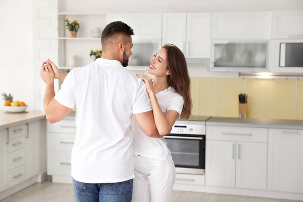 Lovely young couple dancing in kitchen at home - Foto, Imagem
