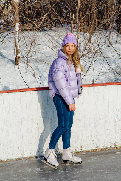 Lovely young woman riding ice skates on the ice rink. - Fotoğraf, Görsel