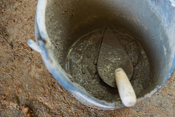 Ramasser une truelle et béton mélangé de ciment est compacté sable
. - Photo, image
