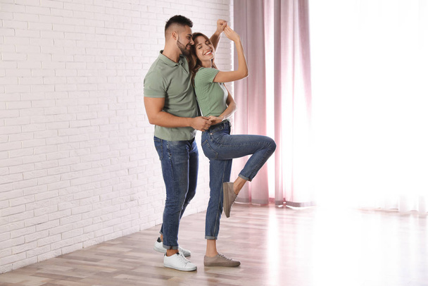Lovely young couple dancing together at home - Фото, изображение
