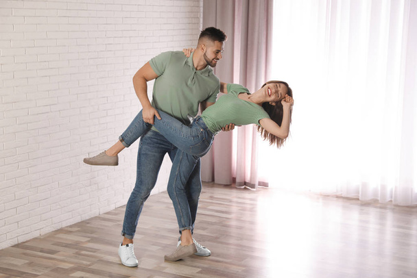 Lovely young couple dancing together at home - Foto, Imagen