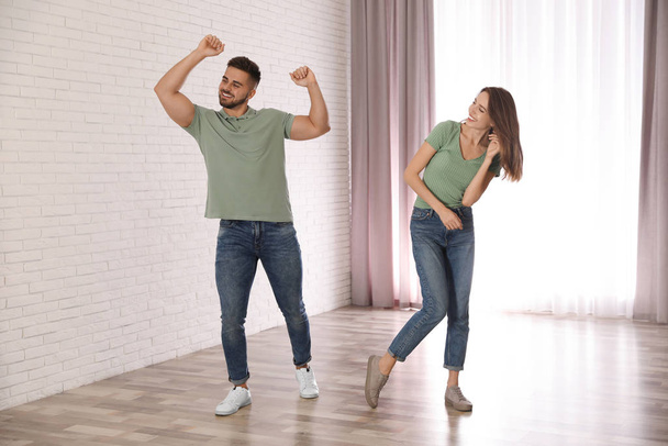 Lovely young couple dancing together at home - Foto, afbeelding