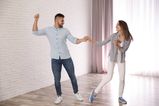 Lovely young couple dancing together at home - Fotografie, Obrázek