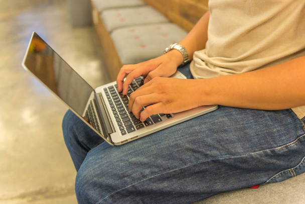 Foto de close-up de humano colocando laptop na coxa e digitação
  - Foto, Imagem