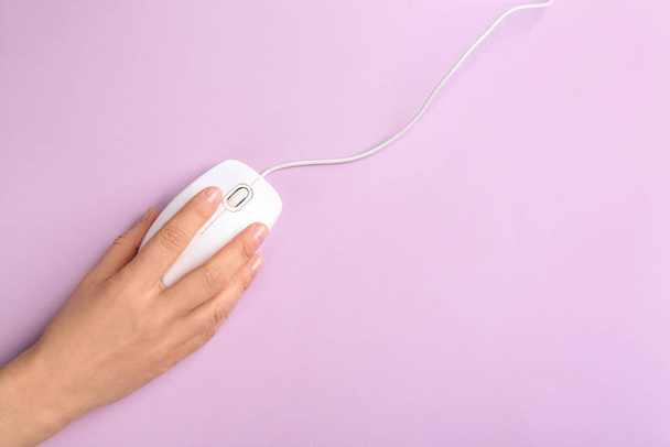 Woman using modern wired optical mouse on lilac background, top  - Foto, imagen