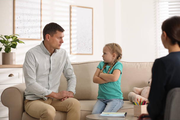 Little girl and her father on appointment with child psychotherapist indoors - Foto, Imagen