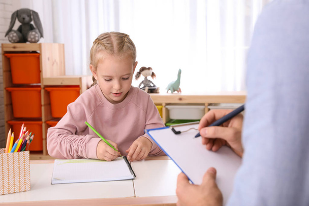 Little girl on appointment with child psychotherapist indoors - Photo, image