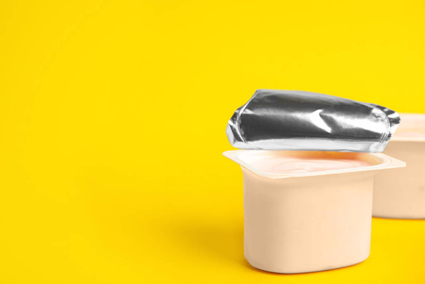 Tasty organic yogurt on yellow background. Space for text - Foto, afbeelding