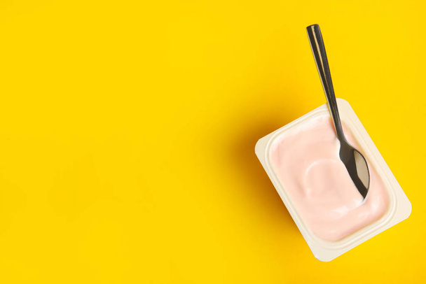 Tasty organic yogurt on yellow background, top view. Space for text - Foto, immagini
