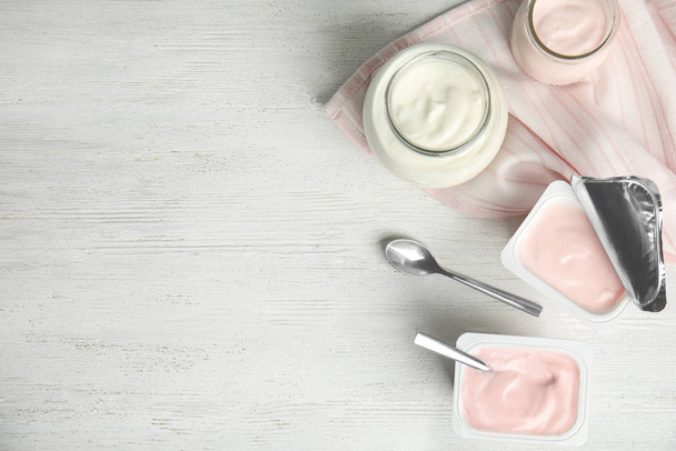 Tasty organic yogurt on white wooden table, flat lay. Space for text - Фото, зображення