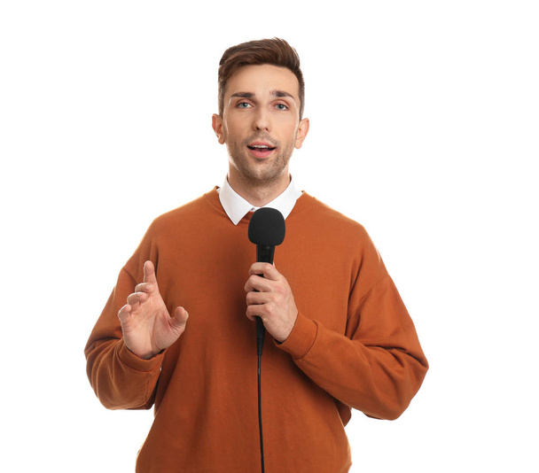 Young male journalist with microphone on white background - Valokuva, kuva