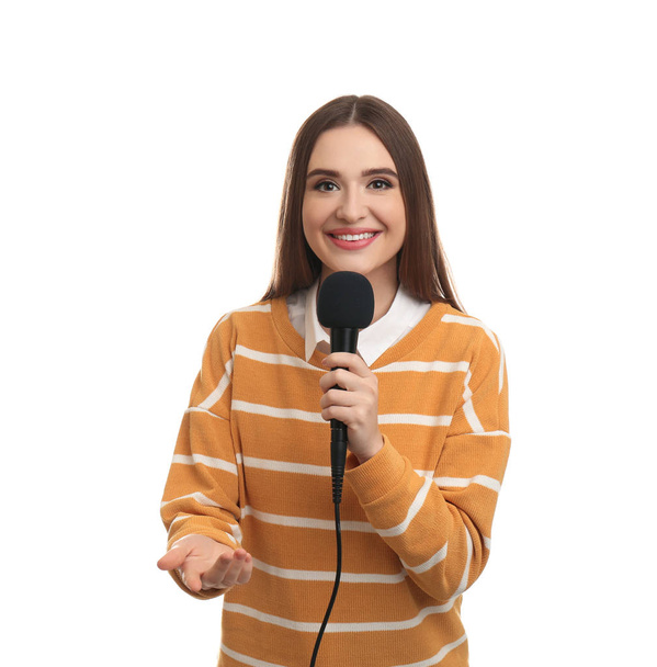 Young female journalist with microphone on white background - 写真・画像