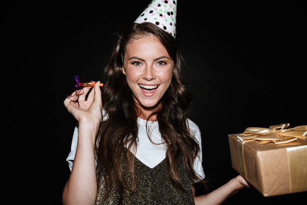 Image of cute happy woman holding gift box and pipe while smiling - Photo, Image