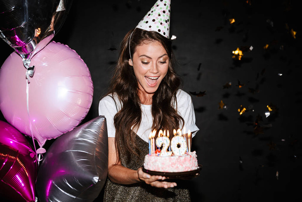 Image of caucasian excited woman holding cake while smiling - Фото, изображение