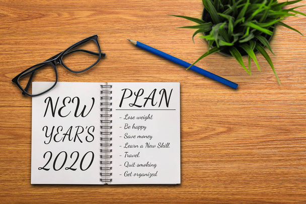 Business Office desk muistikirja kirjoitettu käsin suunnitelmasta listaus uuden vuoden tavoitteet ja päätöslauselmat, joissa
. - Valokuva, kuva