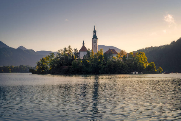 Scenic view of Lake Bled island with church and colorful autumn  - Photo, Image