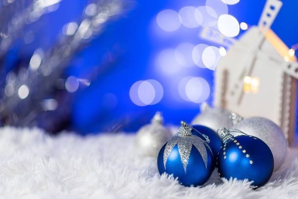 New Year card with Christmas toys on a white plaid. Blurry abstract blue background with lanterns in the bokeh. - Fotoğraf, Görsel