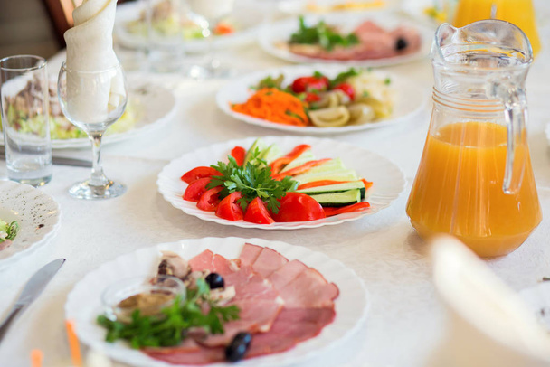 Verduras rebanadas y embutidos en un plato servido en una mesa en un restaurante para un banquete
 - Foto, imagen