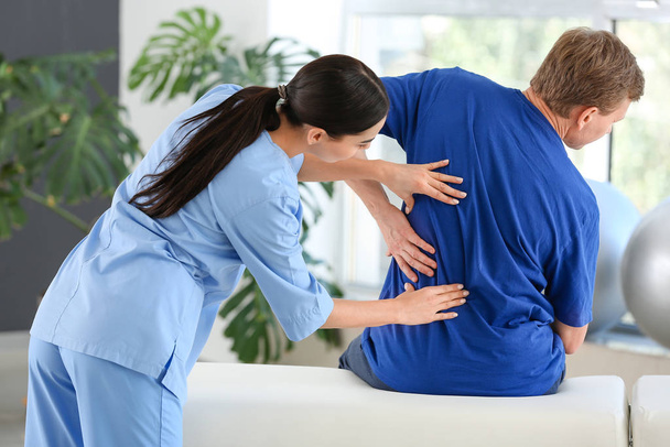 Physiothérapeute travaillant avec un patient masculin dans un centre de réadaptation
 - Photo, image
