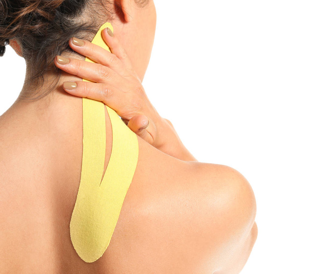 Αθλητική γυναίκα με ταινία physio εφαρμόζεται στο λαιμό σε λευκό φόντο, closeup - Φωτογραφία, εικόνα
