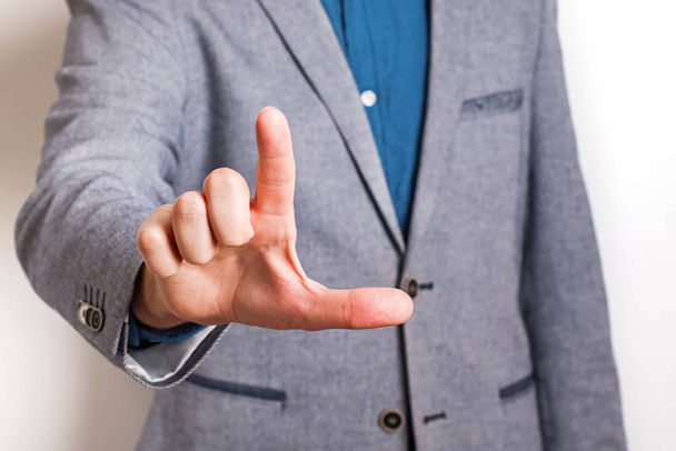 Man wearing suit pointing with his forefinger close-up. - Photo, Image
