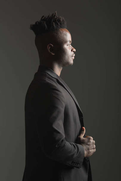 handsome african man in black suit on gray background - Foto, imagen