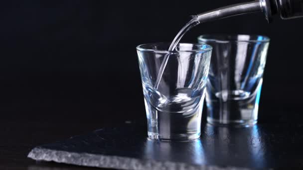 alcohol vodka poured in glasses on a dark background - Filmati, video