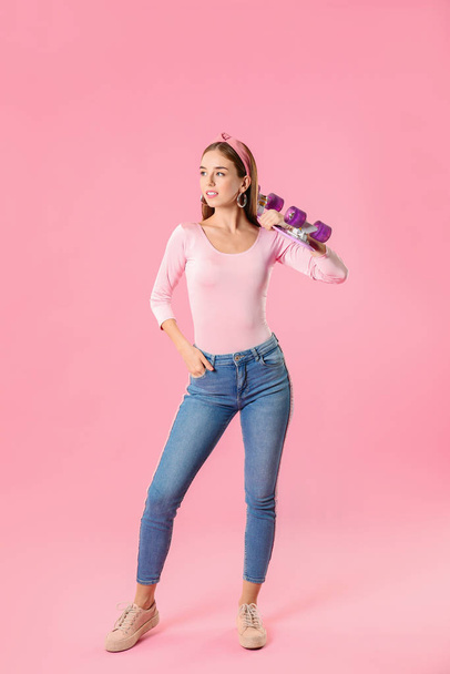 Stijlvol hipster meisje met skateboard op kleur achtergrond - Foto, afbeelding