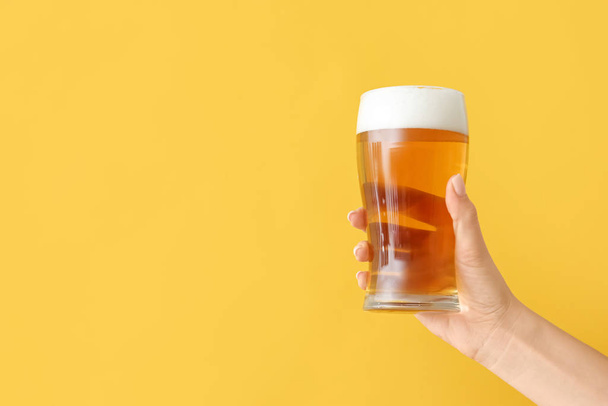 Kéz üveg sör színes háttér - Fotó, kép