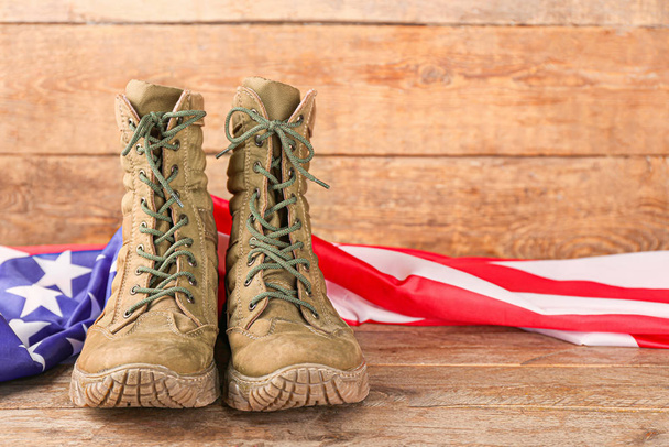 Military boots and USA flag on wooden background. Memorial Day celebration - Foto, afbeelding