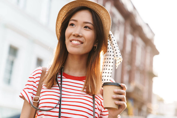 Portrait of pleased asian tourist woman walking through city str - Фото, зображення