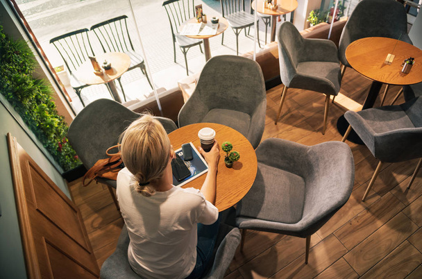 Blonde woman drinking coffee at cafe - Фото, зображення