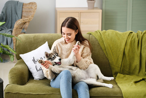 Young woman with funny husky puppy resting at home - Photo, Image