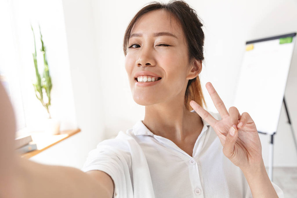 Smiling lovely asian businsswoman taking a selfie - Foto, Imagen