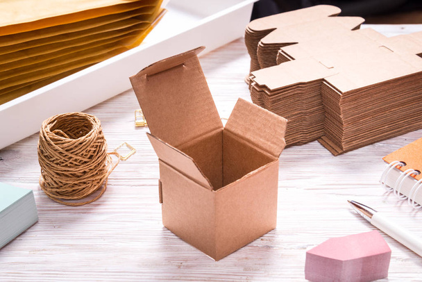 Brown carton box on wooden table for favours - 写真・画像