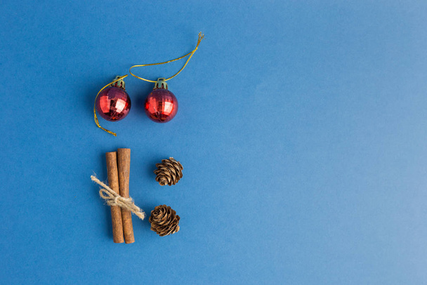 Noel süsleri, koniler ve tarçınlı mavi Noel arkaplanı. Düz yatış stili. Yılın rengi. - Fotoğraf, Görsel