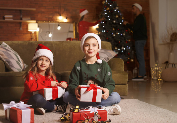 Małe dzieci z prezentami świątecznymi w domu - Zdjęcie, obraz