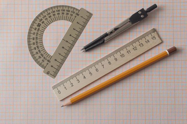 Geometria készlet iránytűvel, ceruzával, vonalzó grafikonpapíron - Fotó, kép