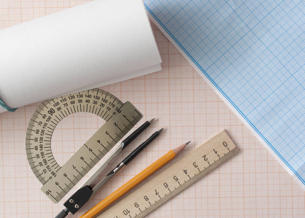 Набор геометрии с компасом, карандашом, линейкой на графической бумаге - Фото, изображение