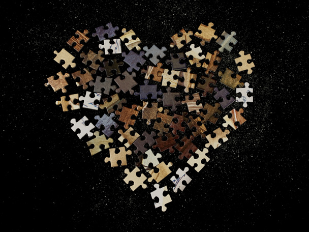 Pozadí textura: tvar srdce na pozadí puzzle papíru. Puzzle v detailech ve formě mozaiky. Koncept: láska, vztahy, jednota, srdečnost. - Fotografie, Obrázek