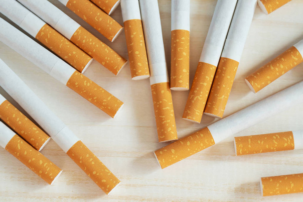 Beyaz ahşap arka planda ticari olarak yapılmış birkaç sigara yığını resmi. sigara içilmeyen kampanya konsepti, tütün desenli üst görünüm. - Fotoğraf, Görsel
