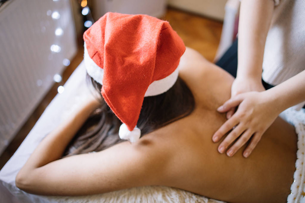 Girl lying on massage bed in spa salon receiving massage - Фото, зображення