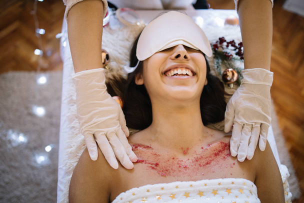 Professional therapist scrubbing woman skin in health SPA - 写真・画像