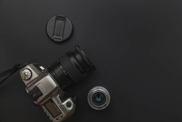 Photographer workplace with dslr camera system and lens on dark black table background. Hobby travel photography concept. Flat lay top view copy space. - Photo, Image